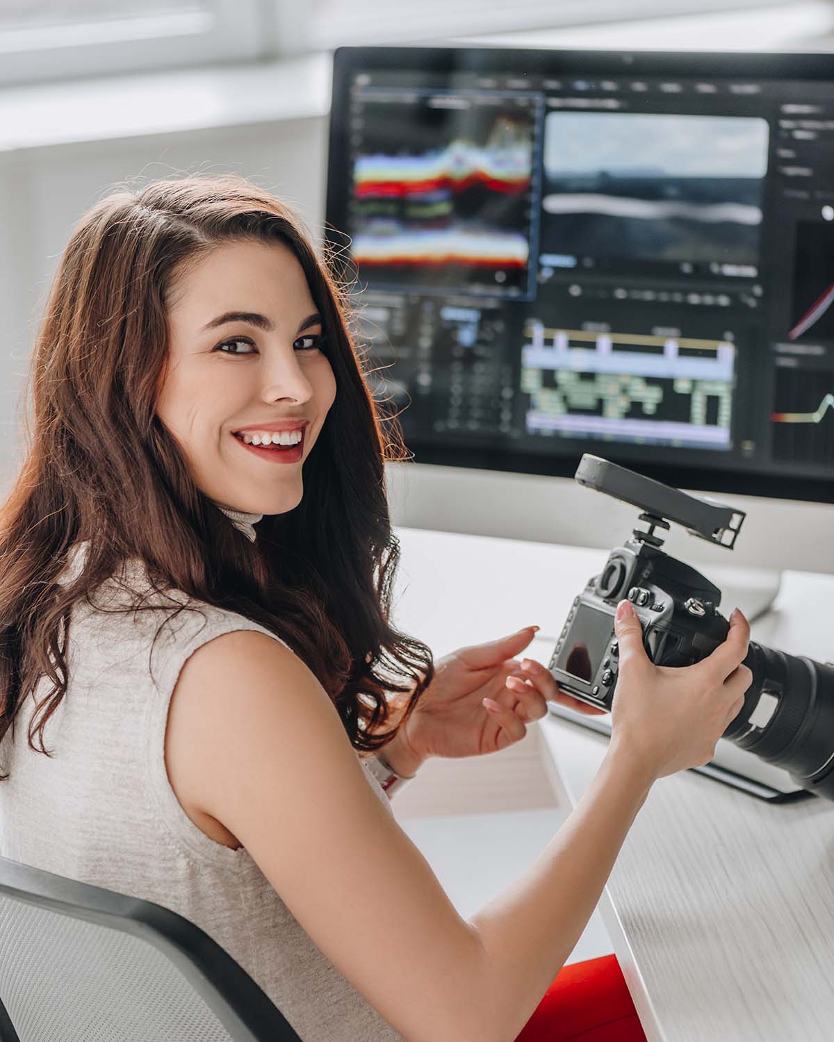 happy-art-editor-holding-digital-camera-near-table-L4NN6PA.jpg